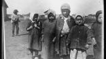 Маленькие беспризорники в бараках беженцев вынуждены носить любую одежду, которую они могут достать, независимо от ее размера или состояния. Маленькие беспризорники в бараках беженцев вынуждены носить любую одежду, которую они могут достать, независимо от ее размера или состояния.